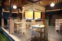 patio ze stołami i krzesłami oraz barem w obiekcie Mathura Ubud w mieście Ubud