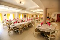 un salón de banquetes con mesas y sillas con arcos rojos en Magnificat Center, en Bijakovići