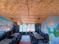 una sala da pranzo con tavoli, sedie e un murale di Apna Ghar Hotel And Resort a Chaukori