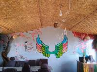 un muro con un murale di un uccello colorato di Apna Ghar Hotel And Resort a Chaukori