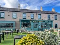 un edificio con mesas y bancos delante de él en Greystones Glamping - Tent 1, en Greystones