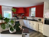 a kitchen with red walls and white cabinets and plants at Maison avec piscine proche de Montpellier in Saint-Brès