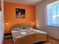 a bedroom with a bed with an orange wall at Apartment Danica in Malinska