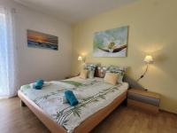 a bedroom with a bed with blue pillows on it at Apartment Danica in Malinska