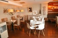 Un restaurante con mesas y sillas y un sofá. en Hotel GH Guaparo Suites Valencia, en Valencia