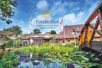 Una vista del frente del hotel con un estanque. en Ringhotel Forellenhof, en Walsrode