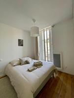 a white bedroom with a large bed with a window at Montfaucon - Élégant appartement &amp; terrasse au cœur de Bordeaux, idéalement situé in Bordeaux