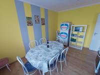 a dining room with a table and a refrigerator at AMRI Apartman in Balatonföldvár
