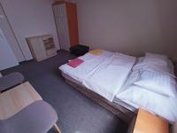 a small bedroom with a bed and a chair at AMRI Apartman in Balatonföldvár