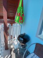 a green umbrella sitting next to a chair and a table at AMRI Apartman in Balatonföldvár