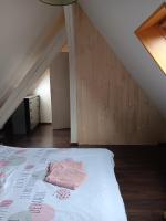a bed with a pink blanket on it in a attic at Superbe gite au centre de Kaysersberg avec 3 chambres in Kaysersberg