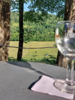 Cocon de Verdure avec piscine chambre lit king-size 2m في Lusignan-Petit: وجود كأس من النبيذ على طاولة مطلة