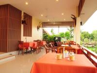 een restaurant met tafels en stoelen en een televisie bij Baan Chay Namm Resort in Bangkok