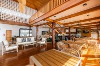 een restaurant met houten vloeren en tafels en stoelen bij Thammachard29 Resort Baangrood in Thong Chai