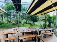 a long wooden table with benches and chairs in a garden at Sun Valley Homestay Bảo Lộc in Bao Loc