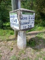 a sign on top of a pole in the grass at L&#39;Armandière, maison de caractère où règne calme et sérénité. in Pézenes-les-Mines