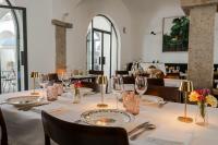 uma sala de jantar com uma mesa com pratos e copos em Casa Amor Olhão em Olhão