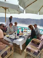 un gruppo di persone seduti intorno a un tavolo su una barca di Miskaa Nubian House a Naj‘ Tinjār