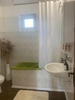 a bathroom with a green tub and a sink at Apartment Angelina 