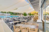 Un patio al aire libre con mesas y sillas y una piscina. en Pestana Blue Alvor Beach - All Inclusive Hotel, en Alvor