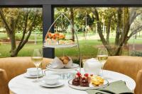 シドニーにあるSheraton Grand Sydney Hyde Parkの食べ物の皿とワインのグラスが置かれたテーブル