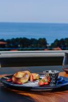 バトゥミにあるTapis Rouge Design Boutique Hotelのテーブルの上に食べ物とカップが置かれた黒い皿