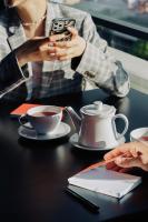 バトゥミにあるTapis Rouge Design Boutique Hotelのコーヒーを飲みながらテーブルに座っている人々のグループ