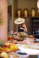 Una mujer con sombrero sentada en una mesa con comida. en Sun Ranch, en Coopers Shoot
