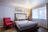 Un dormitorio con una cama y una silla roja. en The Palo Alto Inn, en Palo Alto
