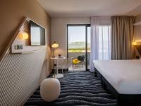 a hotel room with a bed and a desk and a window at ibis Styles Porto Vecchio in Porto-Vecchio