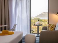 a hotel room with a bed and a large window at ibis Styles Porto Vecchio in Porto-Vecchio