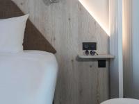 a bedroom with a bed with a speaker on a wall at ibis Styles Porto Vecchio in Porto-Vecchio