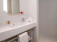 a white bathroom with a sink and a mirror at ibis Styles Porto Vecchio in Porto-Vecchio