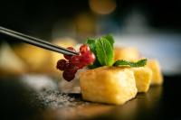 een persoon met een stuk voedsel op een tafel bij Hacienda la Coracera in San Martín de Valdeiglesias