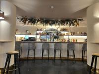 Un bar con cuatro taburetes en una habitación. en Zarú Hotel Boutique, en Mocejón