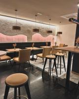 un restaurante con mesas, sillas y paredes rosas en Zarú Hotel Boutique, en Mocejón