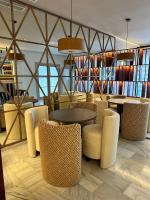 Un vestíbulo con sillas y una mesa y mesas. en Zarú Hotel Boutique, en Mocejón