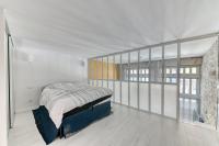 a bedroom with a bed in a room with windows at GuestReady - Stonewall Mezzanine in Brotteaux in Lyon