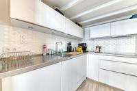 a kitchen with white cabinets and a sink at GuestReady - Stonewall Mezzanine in Brotteaux in Lyon
