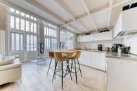 a kitchen with white cabinets and a table and chairs at GuestReady - Stonewall Mezzanine in Brotteaux in Lyon
