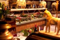 a counter in a restaurant with a table with food at Hôtel Château de Cavanac in Carcassonne