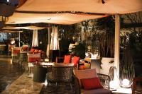 een restaurant met tafels en stoelen en een parasol bij Mondrian Mexico City Condesa in Mexico-Stad