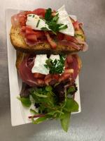 deux sandwichs avec de la viande et des légumes dans une assiette dans l'établissement Complexe les 4 saisons, à Oust