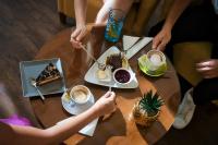 Un grupo de personas sentadas en una mesa con café y postre. en BRISTOL Hotel Opatija, en Opatija