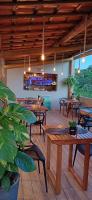 a restaurant with wooden tables and chairs and a bar at Pousada Mon Gâté in Japaratinga