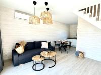 a living room with a blue couch and tables at Baltic Atelier domki nad morzem in Grzybowo