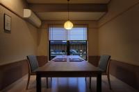 una sala da pranzo con tavolo, sedie e una finestra di Ryokusuitei a Kamogawa