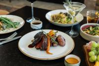 a table with plates of food and glasses of wine at The Embers Hotel in Blowing Rock
