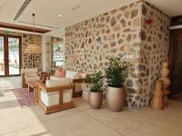uma sala de estar com uma parede de pedra com vasos de plantas em Najd Al Meqsar, By Sharjah Collection - Adults Only em Khor Fakkan