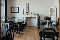 una sala da pranzo con tavoli e sedie e un camino di La Maison des Dames a La Sauvenière